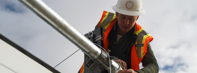 Trabajador de la construcción asistiendo a un compañero herido en una obra, haciendo hincapié en la seguridad en el lugar de trabajo y la respuesta ante accidentes
