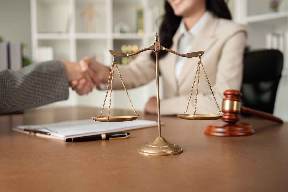 a-lawyer-and-a-businesswoman-shake-hands-and-reach-2024-03-26-21-00-25-utc (1) un abogado y un cliente se dan la mano tras ganar el caso