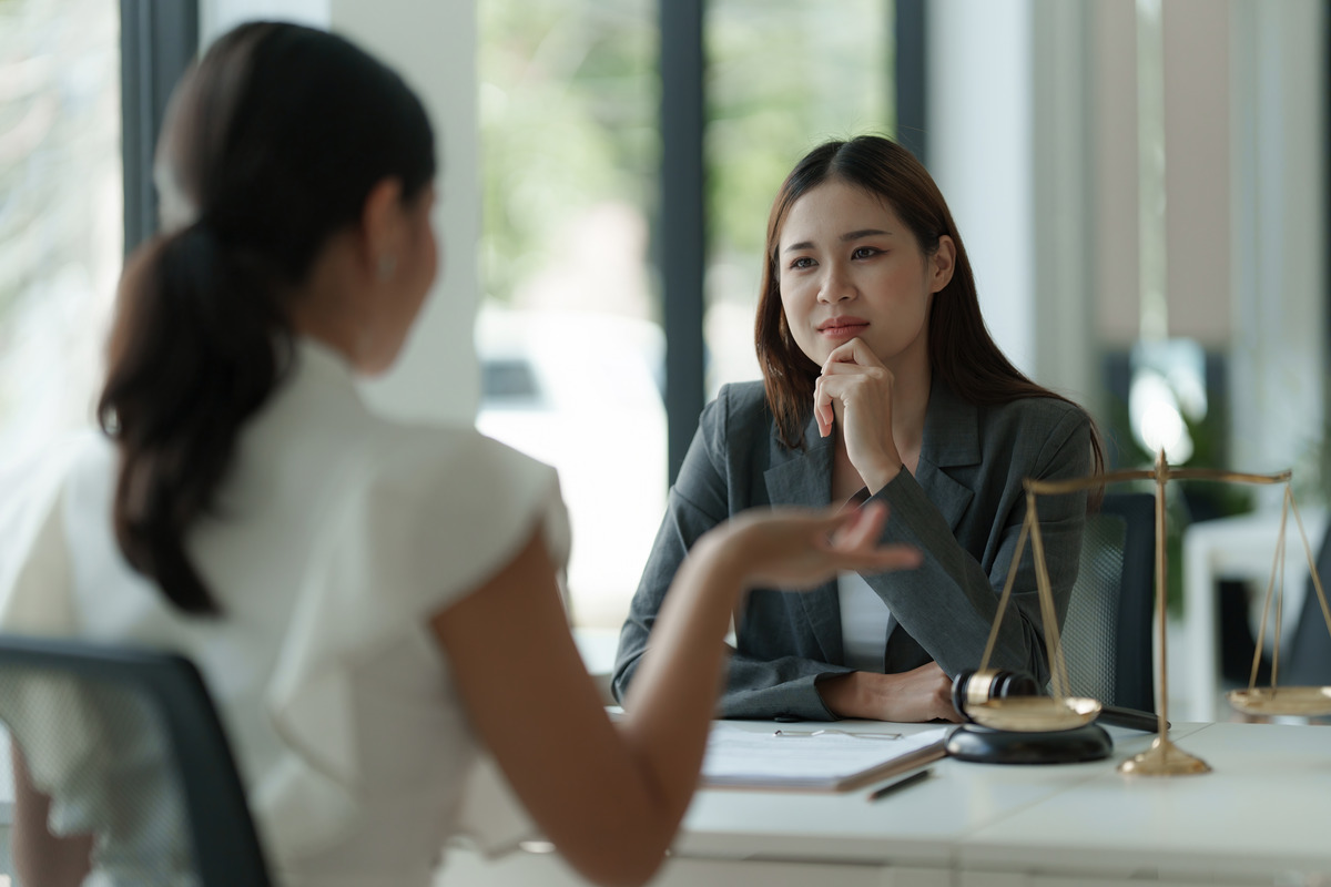 business-woman-and-lawyers-discussing-contract-pap-2023-11-27-05-01-01-utc (1) Documento de demanda con un mazo encima