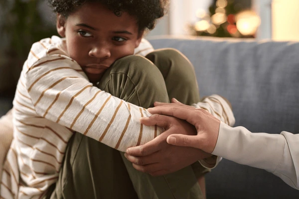 close-distressed-african-american-boy-600nw-2475305831 Primer plano de un niño pequeño angustiado, representando el impacto emocional de accidentes o traumas