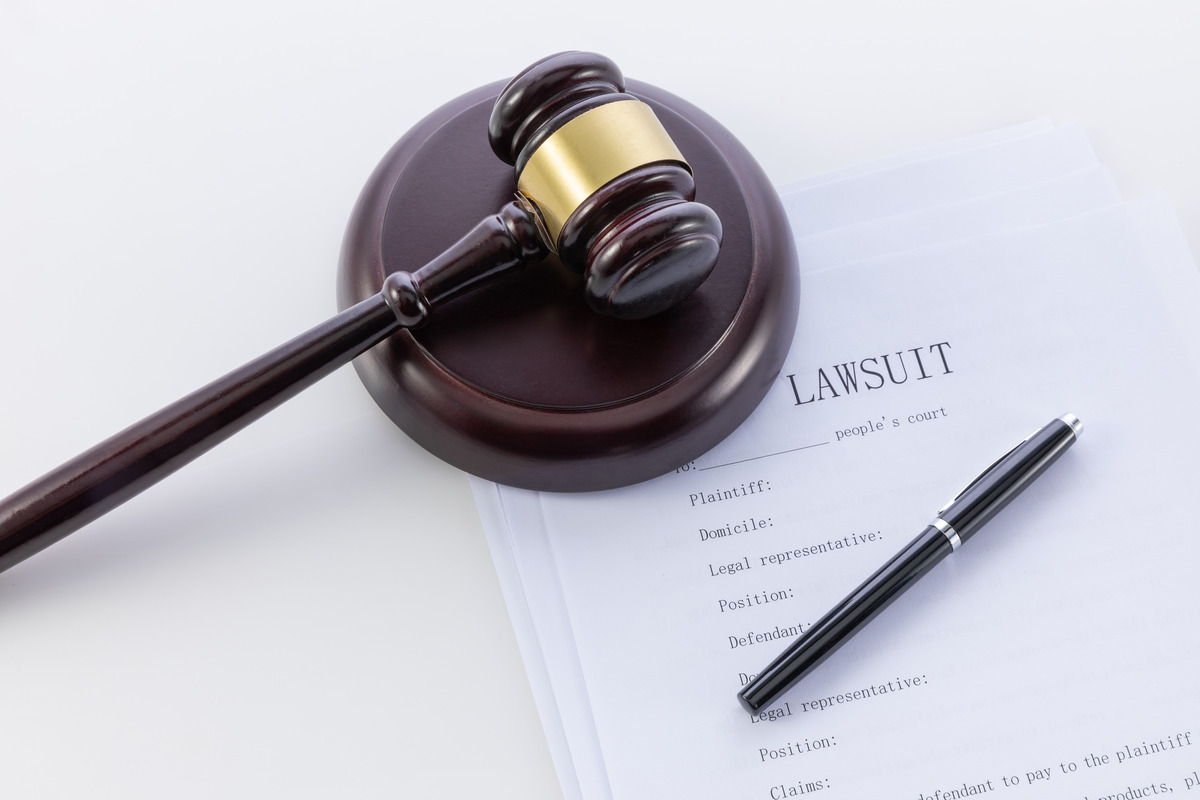 Papeles legales con un mazo sobre un escritorio, toma cenital que representa un caso judicial