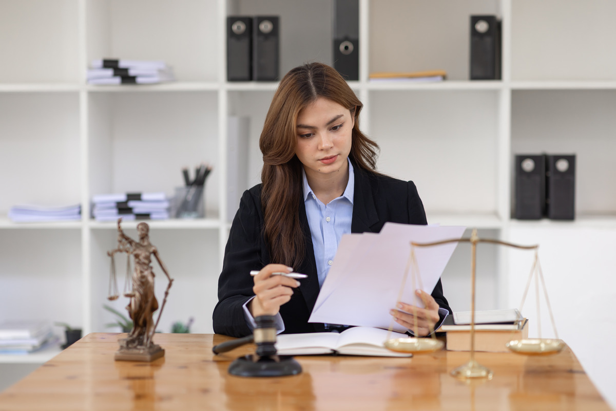 Abogado profesional analizando expedientes de casos y papeleo en una oficina moderna para servicios de consulta legal