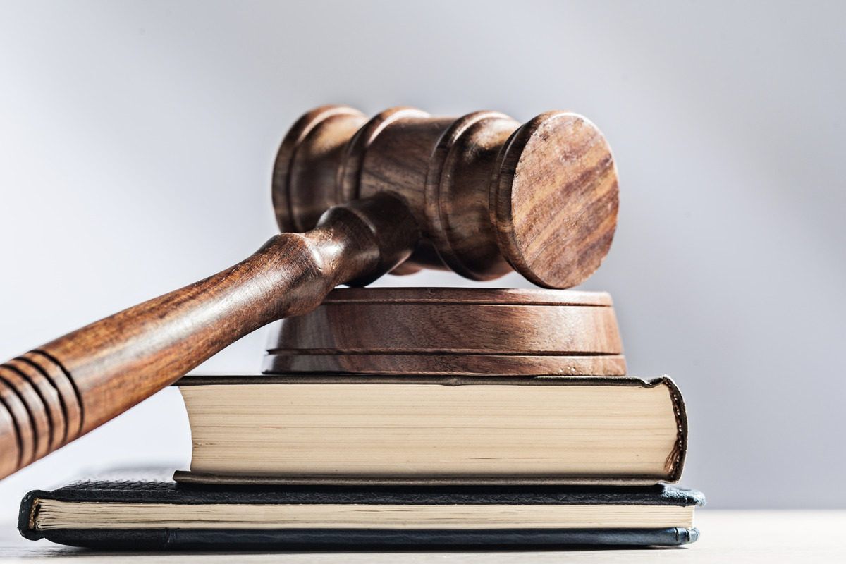 Mazo de juez de madera sobre libros legales, representando justicia, sistema legal, procedimientos judiciales y autoridad legal