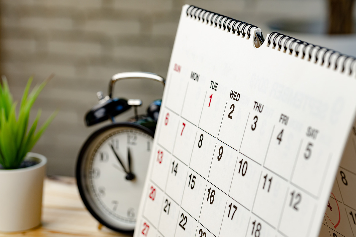 Calendario y reloj despertador sobre un escritorio, simbolizando plazos legales, estatutos de limitaciones, tiempos para presentar demandas y fechas importantes en reclamos por lesiones personales y litigios.