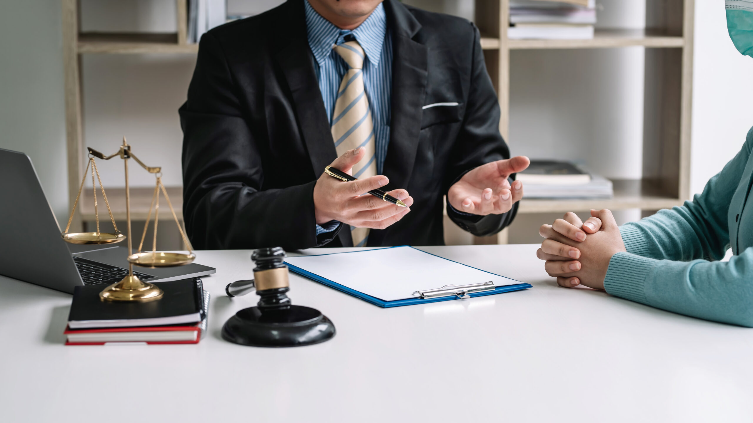 Abogado de lesiones personales consultando con un cliente en una oficina legal, analizando opciones legales, reclamos por accidentes, compensación y estrategia para litigios de lesiones